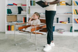 A male therapist guides a young child through a learning activity with colorful flashcards during ABA therapy in a bright, welcoming room.