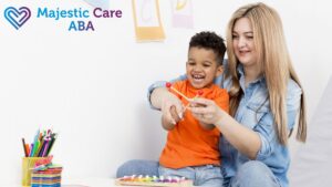 A blonde therapist guides a young girl in therapy, sharing a joyful bonding moment during an autism intervention session.