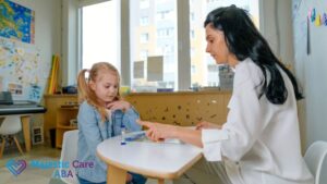 ABA therapy session, a female therapist sits with a child in the classroom for a one-on-one session.