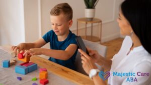 ABA therapy session with a female therapist observing a young boy completing a building block puzzle while recording his progress on a phone.