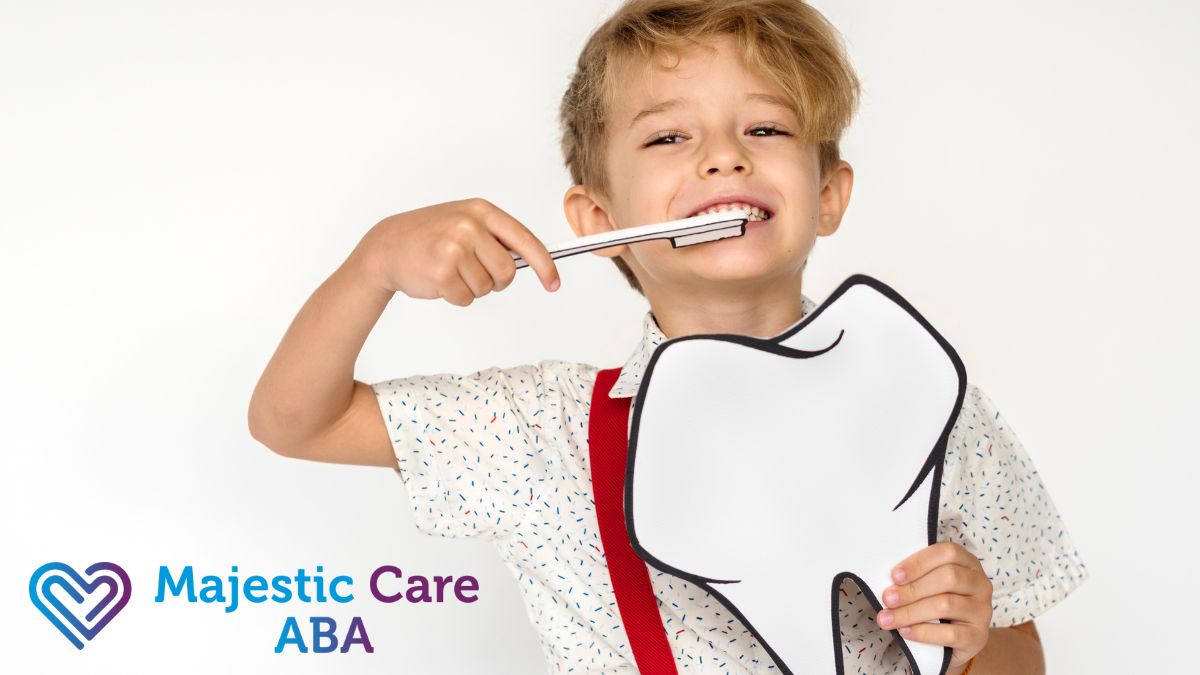 A boy practices autism life skills by brushing his teeth while holding a card with a tooth illustration.