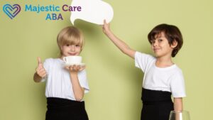 Two boys engaging in a joyful exchange with a talk bubble above them; one boy is holding a cup toward the camera, illustrating verbal behavior in ABA.