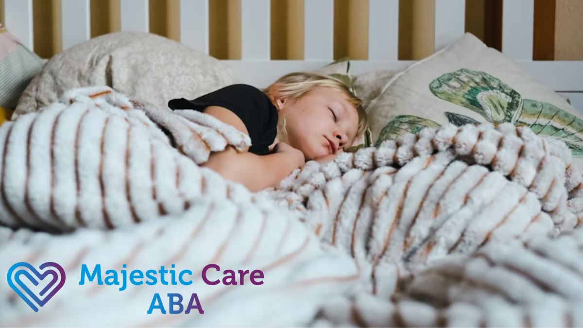 A young girl with autism is shown from a high 90-degree angle asleep on a bed under a heavy weighted blanket.